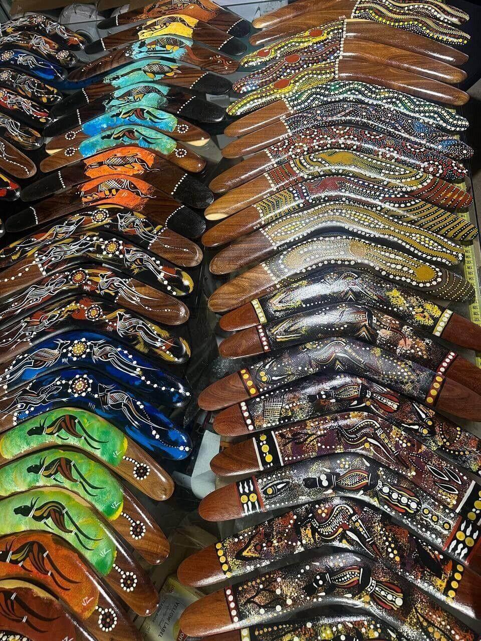 Colorful hand-painted boomerangs with Aboriginal art designs, showcasing cultural patterns and vibrant hues.