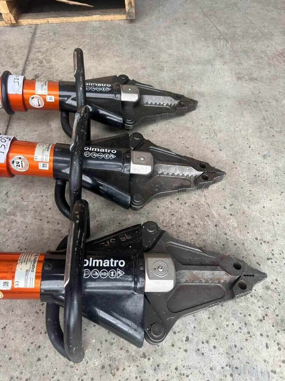 Three Olmatro hydraulic rescue cutters on concrete floor, heavy-duty emergency tools for vehicle extrication