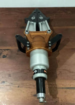 Hydraulic rescue tool with orange and black design, placed on wooden surface