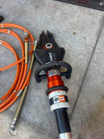 Holmatro Matro hydraulic rescue tool with orange hoses on concrete floor