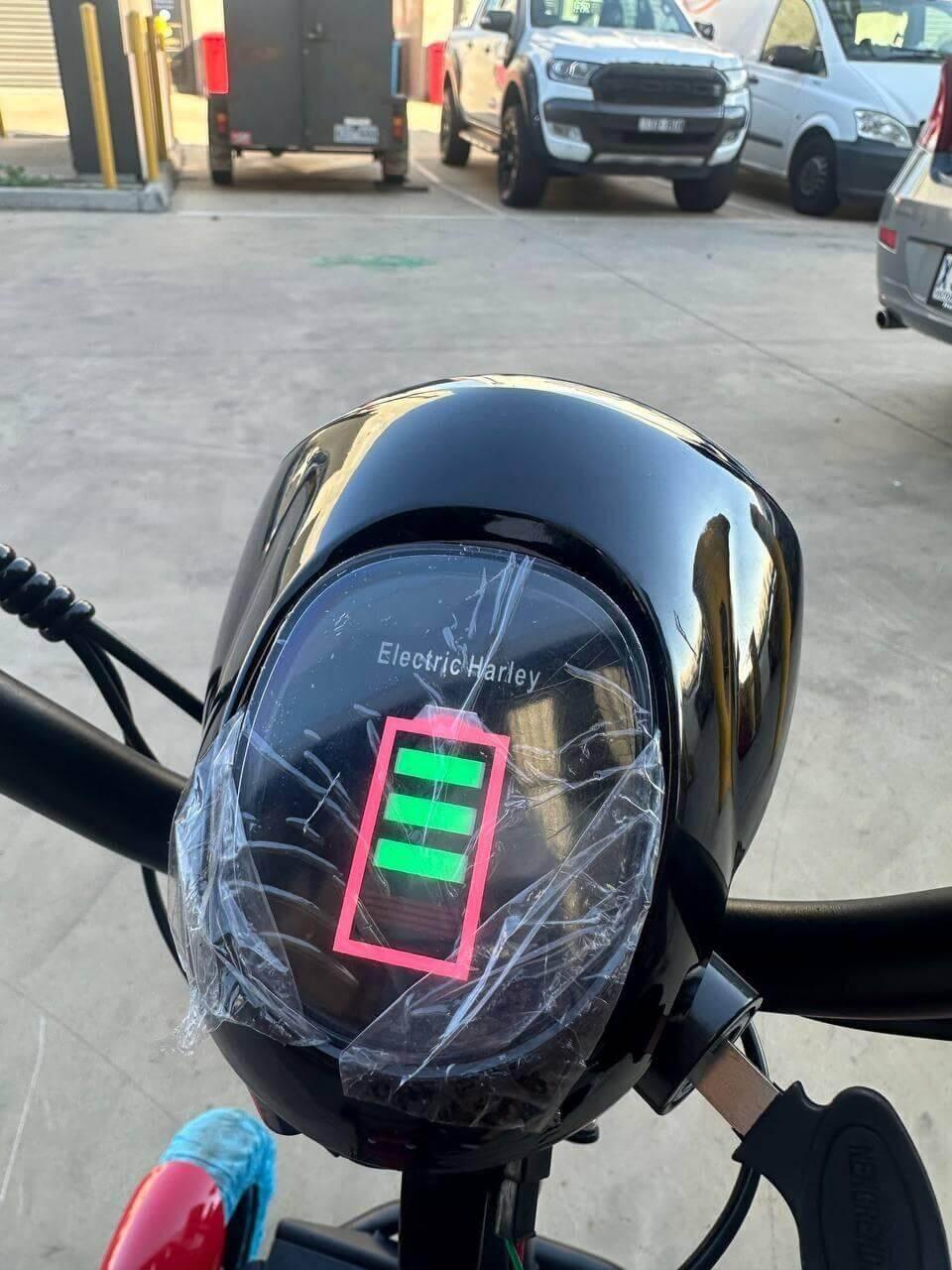 Electric Harley e-bike dashboard with full battery indicator, parked in lot