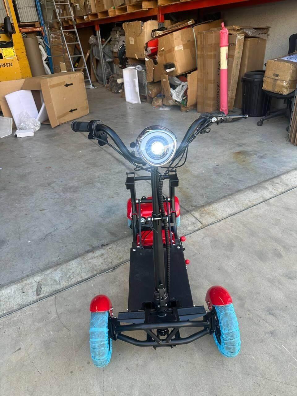 Red and black electric scooter with blue wheels in warehouse setting