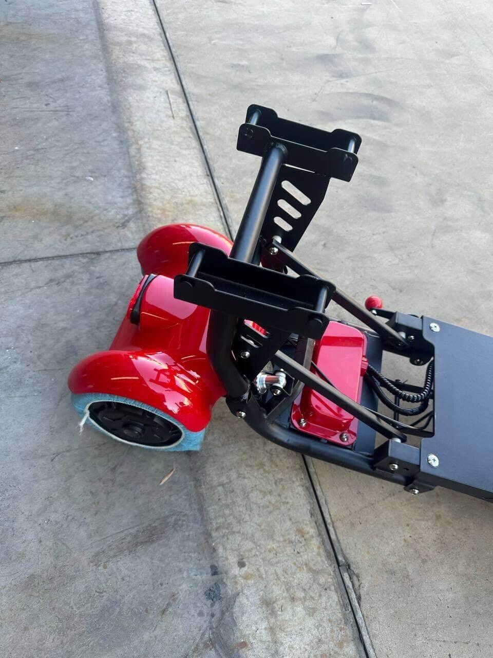 Red electric scooter with black frame and blue wheel, parked on concrete