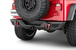 Red Jeep rear with black bumper, red recovery hooks, spare tire, and rugged off-road tires
