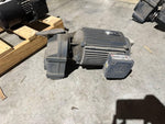 Industrial SEW motor with ribbed casing, placed on concrete floor near wooden pallets