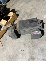Industrial electric motor with ribbed casing, mounted on concrete floor, suitable for tractor or truck parts