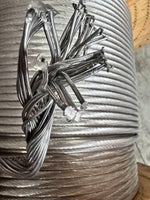 Coiled steel wire rope with frayed ends, ideal for industrial and tractor parts applications.