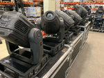 Row of black stage moving head lights on flight cases in warehouse, AT Series