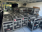 ROBE show lighting equipment cases labeled 700 wash and 1200 spot, stacked in a garage