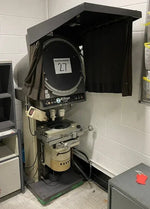 Nikon film projector with black curtain in industrial setting