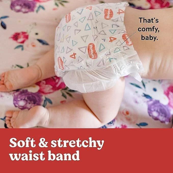 Soft stretchy waistband baby diaper with colorful geometric patterns on floral bedding