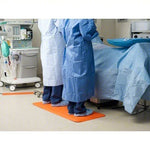 Medical staff in blue and white gowns standing on orange mat in hospital setting