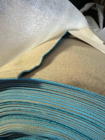 Stacked blue and beige PVC table covers with textured surface, ideal for commercial use