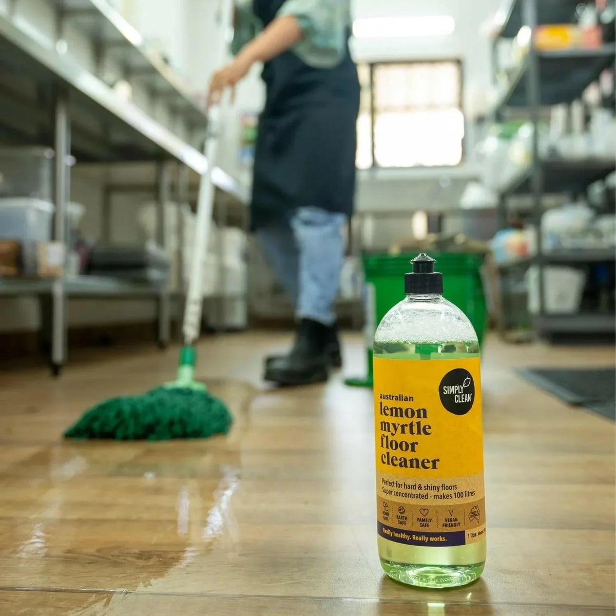 Australian lemon myrtle floor cleaner bottle on shiny wood floor with mop in background