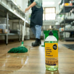 Australian lemon myrtle floor cleaner bottle on shiny wood floor with mop in background