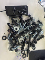 Assorted bolts, nuts, washers, and black metal bracket for tractor or truck parts repair
