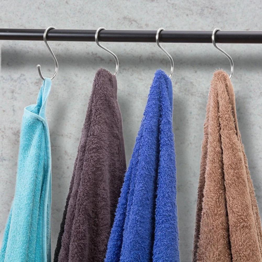 Four colorful microfiber towels hanging on S-hooks from a black rod, ideal for kitchen or workshop use.
