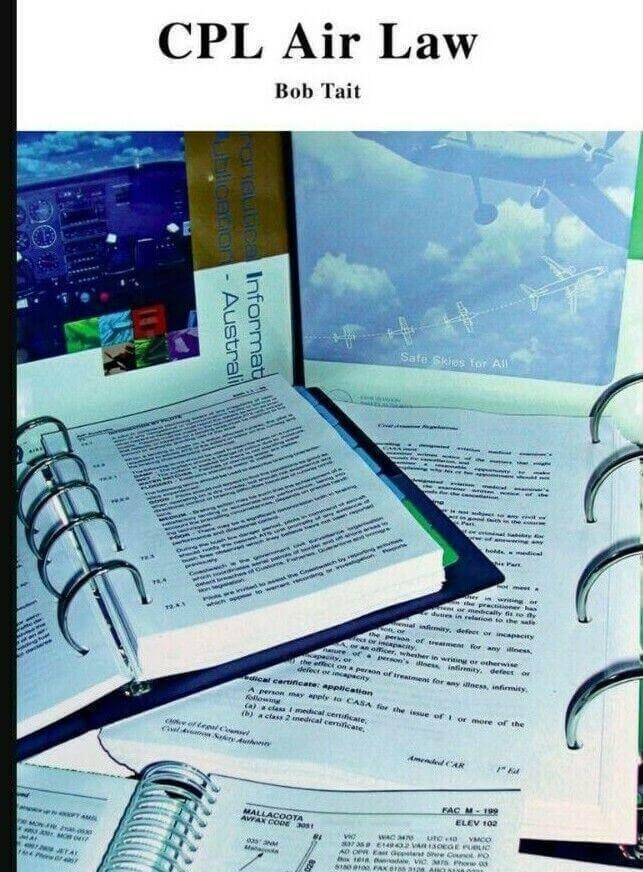 CPL Air Law Bob Tait aviation study guide with open binders, printed pages, and cockpit image