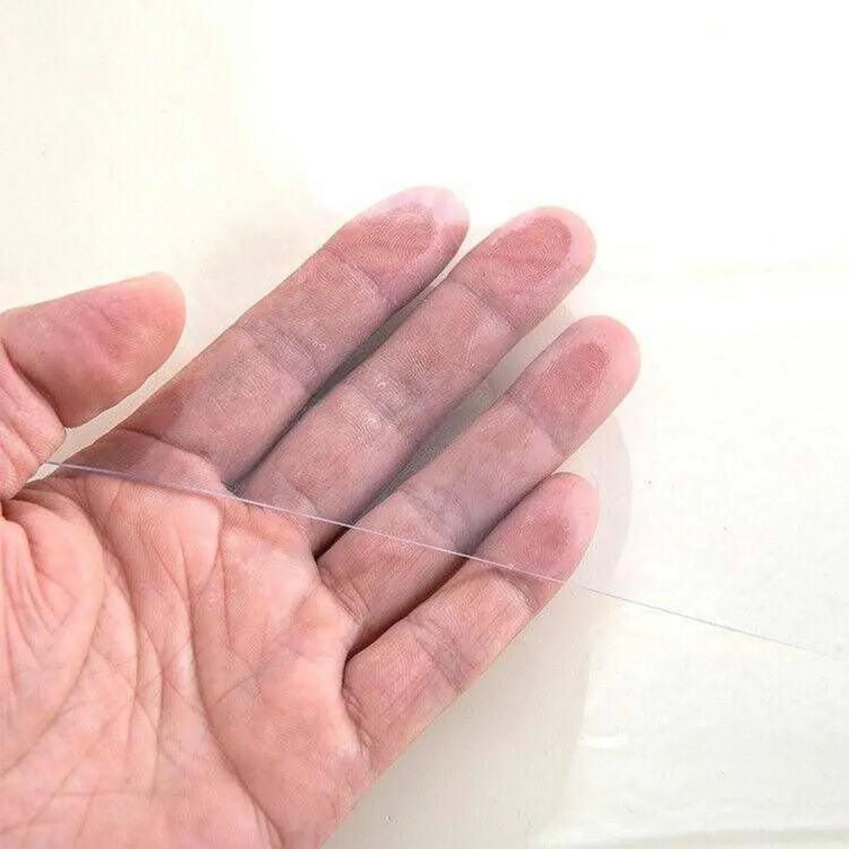 Clear PVC plastic table cover held by hand, showing its transparent protective finish