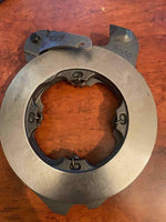 Tractor brake actuator metal component on wood surface, replacement tractor part