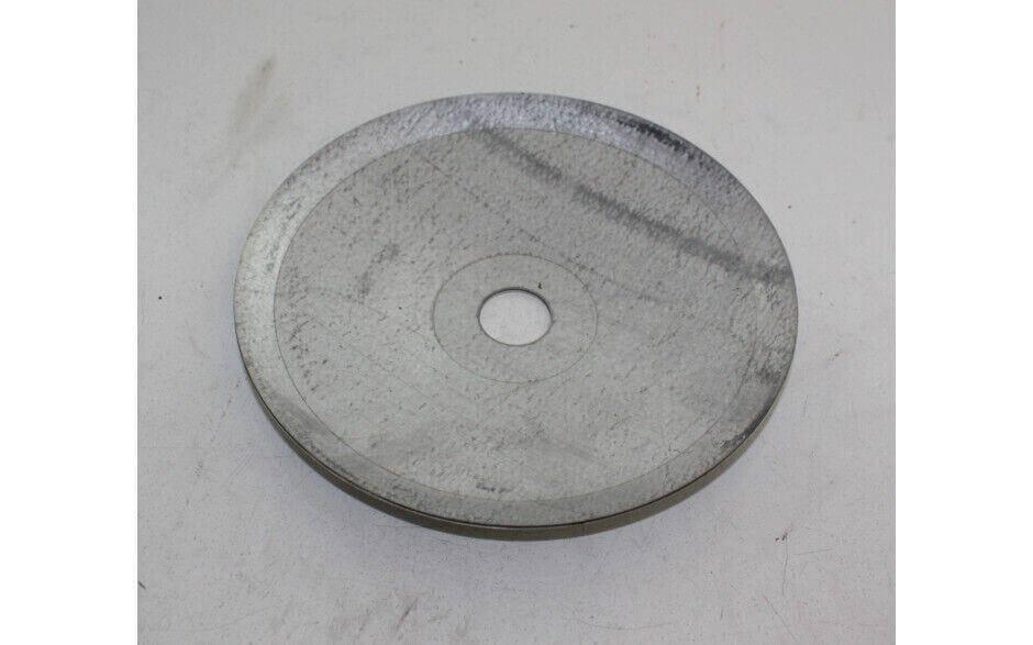 Round metal tractor plate with central hole, replacement part on white background