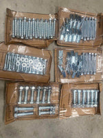 bulk lot of assorted metal nuts, screws, bolts, and washers sorted in cardboard trays