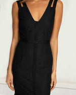 Woman wearing a sleeveless black lace midi dress with V-neck and textured fabric