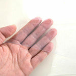Close-up of a hand holding a clear PVC table protector, showcasing its thin and flexible design for table protection.