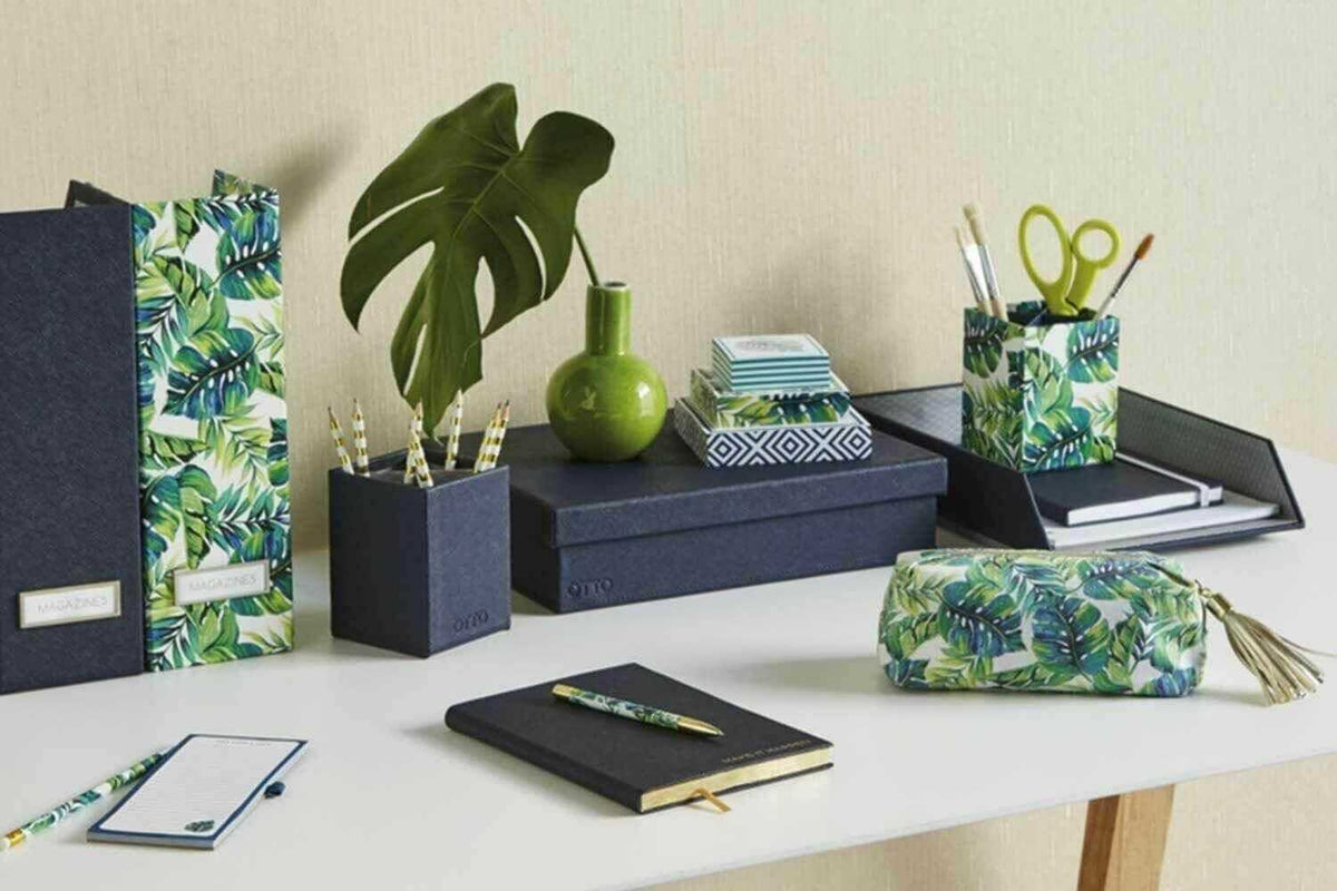 Desk with tropical leaf print stationery set, organizer boxes, pen holder, pouch, and notebooks