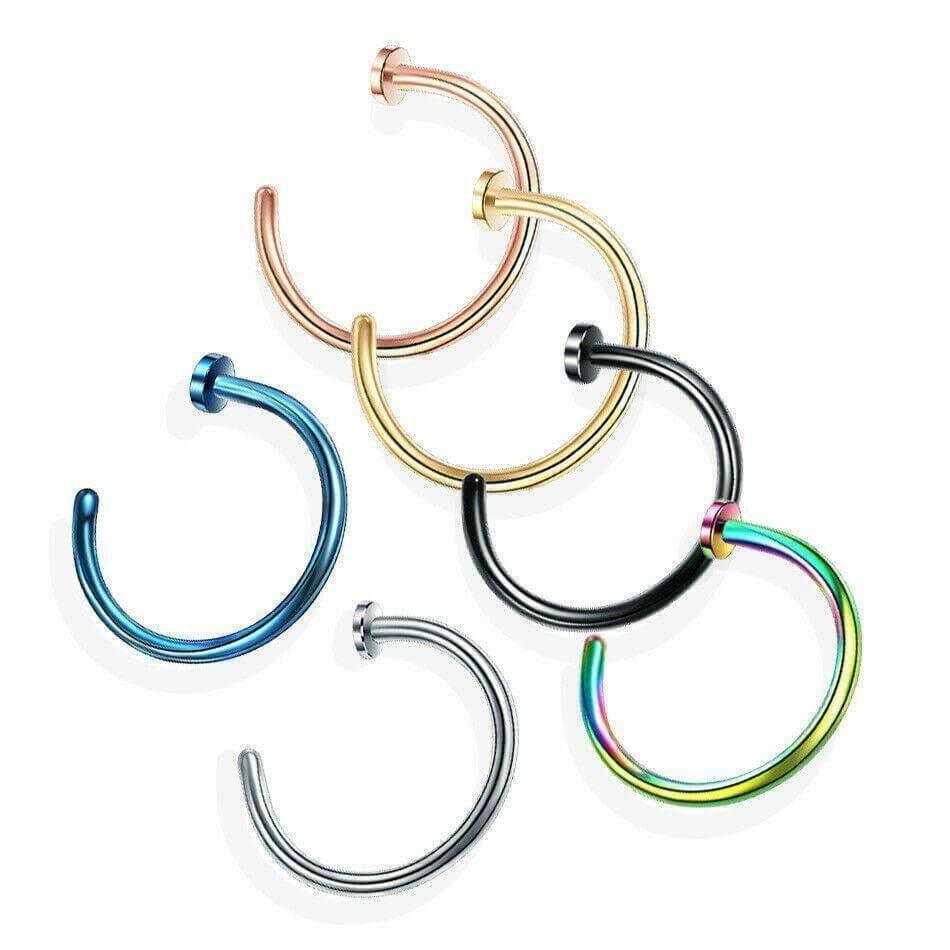 Assorted fake nose rings in silver, gold, black, blue, rose gold, and rainbow colors on white background.