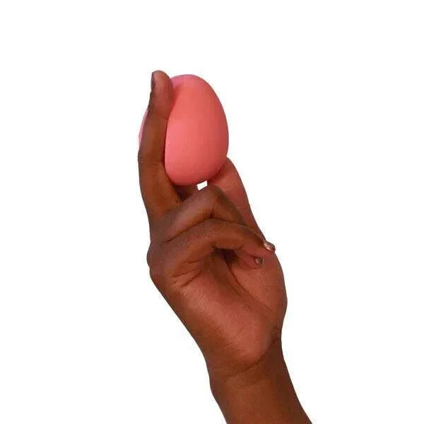 Pink egg-shaped stress ball held in hand for grip and relaxation